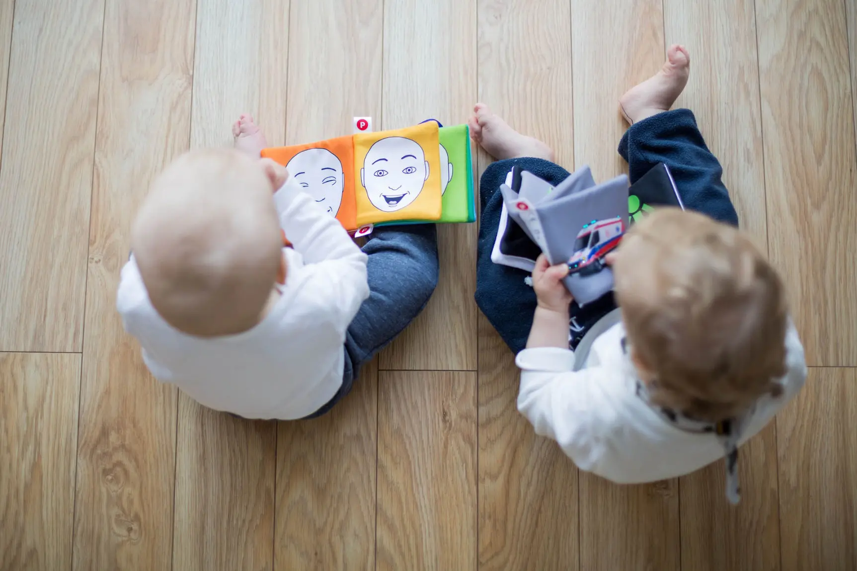 Two toddlers reading books in parallel